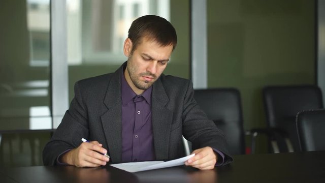 businessman's hand signing document. Man signs paper beside window. New insurance policy. Official letter to a partner.