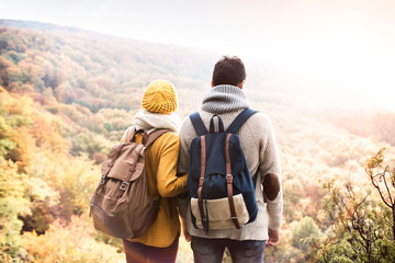 Beautiful couple in autumn nature against colorful autumn forest