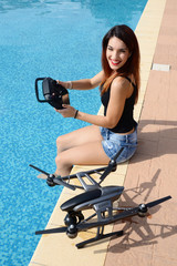 Fototapeta na wymiar girl fly drone with remote control by the swimming pool