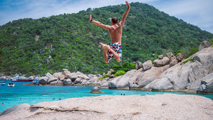 Man jump on the rock of Koh Nang Yuan, Beautiful island, near KohTao, Thailand