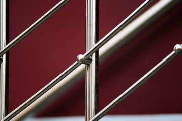 part of chrome ladder in front of red wall. 