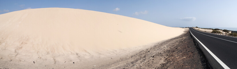 Fuerteventura, Isole Canarie: la strada e le dune di sabbia del parco naturale di Corralejo il 29 agosto 2016: 11 chilometri di dune formatesi dalla sabbia del Sahara portata dal vento