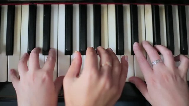 Teaching a child to play a piano.