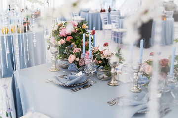 Silver glasswere stand on a blue dinner table decorated with pin