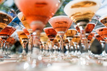 Cocktail glasses full of red alcohol stand on the table