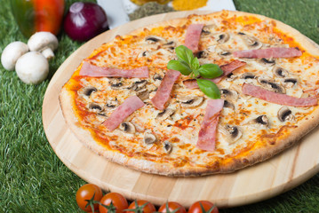 Classic italian pizza with ham and mushrooms on wooden board