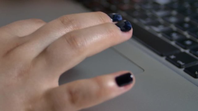 Young Woman Fingers On A Laptop's Track Pad, Surfing The Internet
