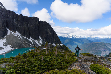 Active traveler hiking, enjoying the view, looking at mountains landscape. Mountaineering sport lifestyle concept. Canada