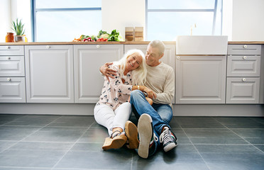 Loving couple sitting on kitchen floor