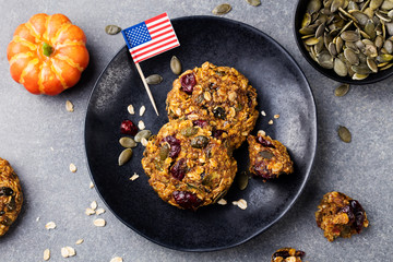 Pumpkin cookies with cranberries and maple glaze with American flag Grey stone background. Top view