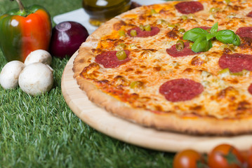 Close up of traditional italian pizza. Thin pastry and many ingredients on it.