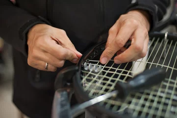 Zelfklevend Fotobehang Stringing Machine. Close up of tennis stringer hands doing racket stringing in his workshop © guruXOX