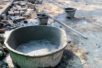 mixed cement in the container with the tool prepared for building