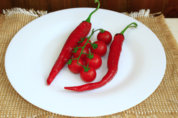 pods of chili peppers and cherry tomatoes on the plate