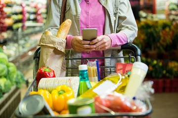 Woman using mobile phone while shopping