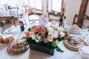 tables decor in the restaurant at wedding ceremony, flowers, food and number table