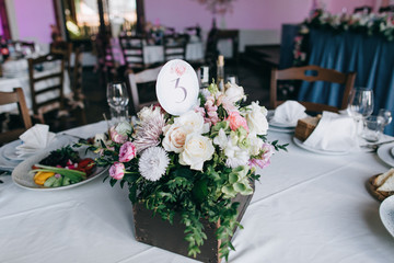 tables decor in the restaurant at wedding ceremony, flowers, food and number table