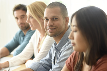 Smiling hispanic businessman attending meeting