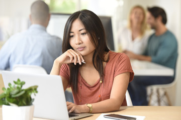 Young asian mixed-race woman working in office