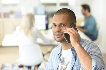 Portrait of office-worker talking on phone