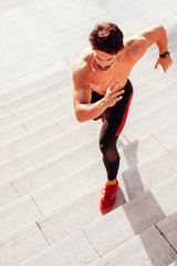 Fototapeta na wymiar Man runner running on stairs in city, sport training.