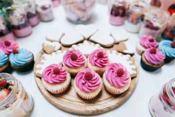 Cakes with raspberries and strawberry jam. Dessert table for a wedding party. 