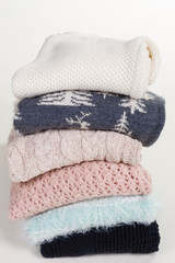 Stack of beautiful handmade sweaters with different patterns.