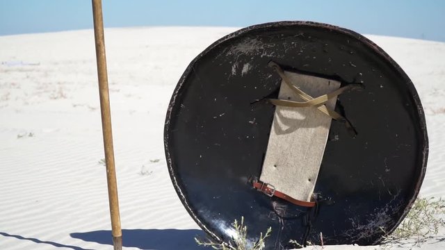 shield and spear in the sand