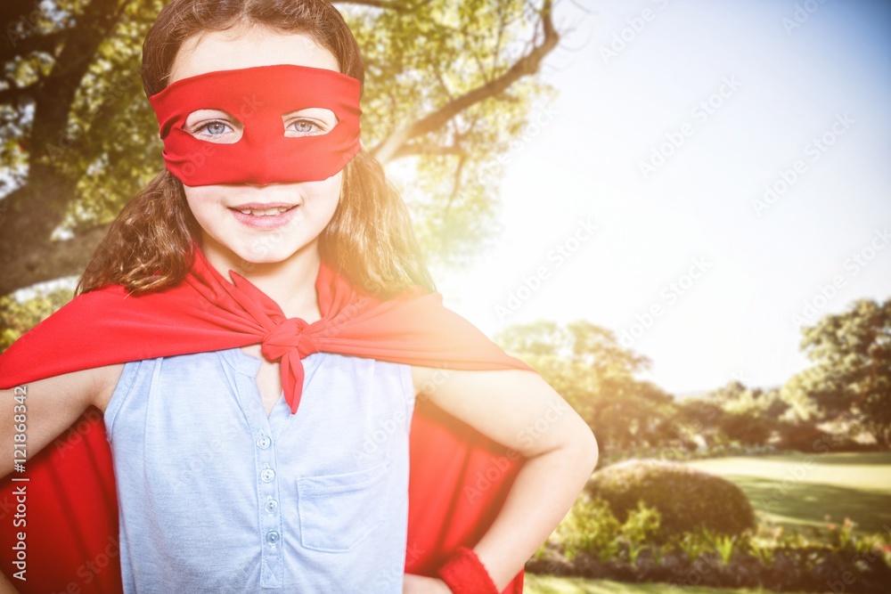 Wall mural Composite image of little girl pretending to be a superhero 