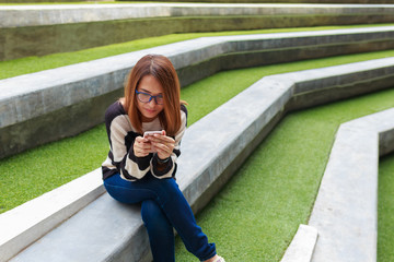 People lifestyle, young girl sitting and using smartphone connected online social outdoors