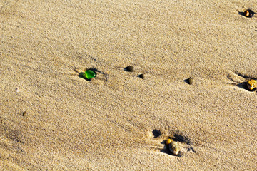 Pebbles and stones washed up in sand