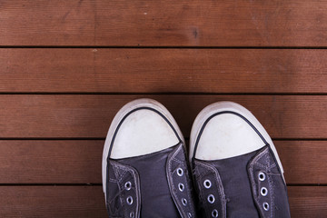 Fototapeta na wymiar Old canvas shoes on a wooden floor