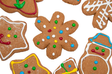 Snowflake gingerbread cookie in the middle of other colorful gingerbread cookies on white background