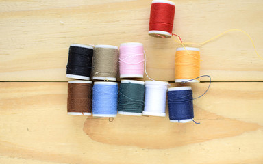 colorful sewing threads on wooden background