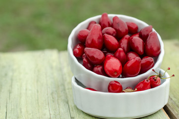 fresh cornel berries in white bowls dogwood in white plates