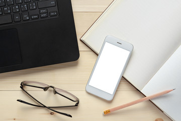 Office desk top view with smartphone white screen, laptop, eyeglasses and books