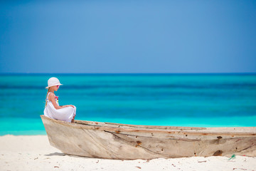 Adorable little girl in white dress at beach during summer vacation