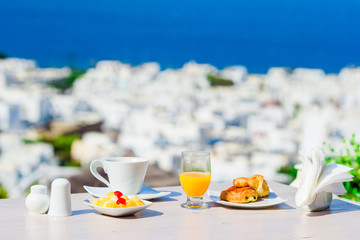 Breakfast served table by the sea. Perfect luxury breakfast table outdoors. Amazing caldera view on Mykonos, Greece, Europe.