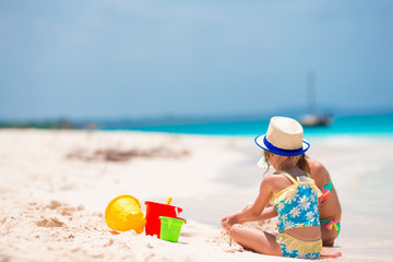 Adorable little girls during summer vacation. Kids playing with beach toys on the white beach