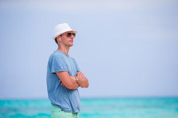 Happy young man enjoying time on white sandy beach