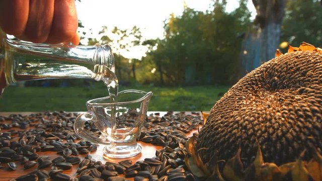 Sunflower oil and sunflower seeds on nature. Slow motion.