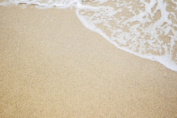 Sand and wave at the beach background. Drop space on bottom right for text and other.