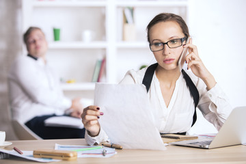 Young lady on phone doing paperwork