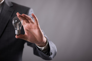 Businessman holding light bulb in creativity concept