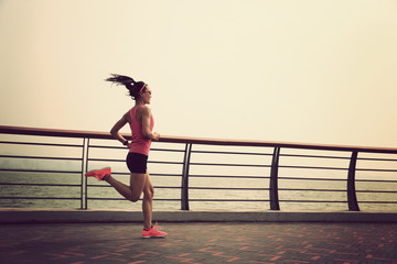 young fitness woman running at seaside