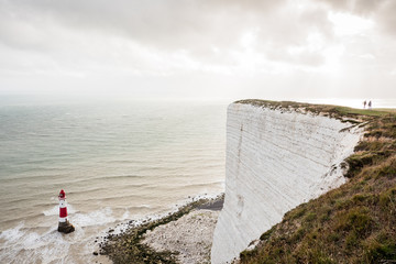White cliffs of Beachy Head with red and white Lighthouse in South Downs, southern England.