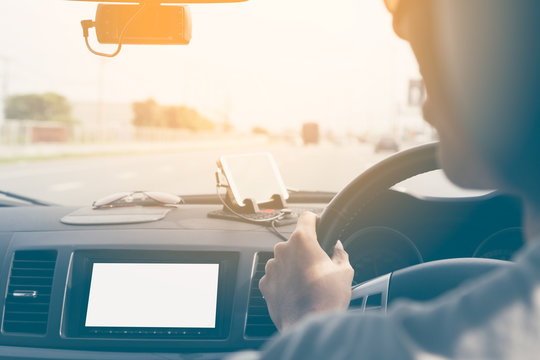 Young Man Driving Car On Road With Blank Screen Monitor Using Connected To Cctv Camera And Connect To Smartphone To See The Map For Traveling, Selective Focus