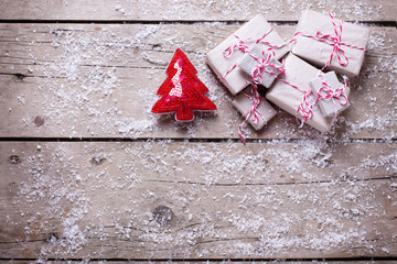 Wrapped christmas presents and decorative fur tree  on aged wood
