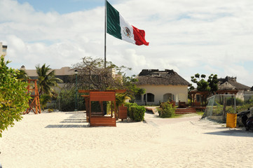 huge Mexican flag on the flagpole on the beach in Cancun
