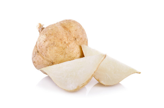 whole and cut yam bean or jicama on white background